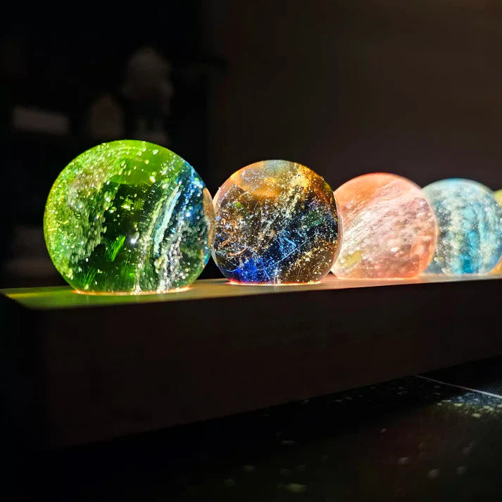 close das esferas coloridas iluminadas da luminária 7 chakras sobre base de madeira