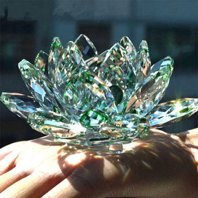 Flor de Lótus de Cristal Feng Shui com pétalas facetadas em tons de verde, refletindo luz e simbolizando pureza e renovação espiritual. Pelicano Azul.