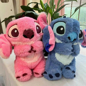 Pelúcias do Stitch rosa e azul lado a lado sobre mesa, com fundo de plantas e janela iluminada.