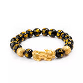 Pulseira da prosperidade Feng Shui com obsidiana negra e charm dourado do Pixiu, simbolizando proteção, sorte e riqueza, para atrair boas energias - Pelicano Azul