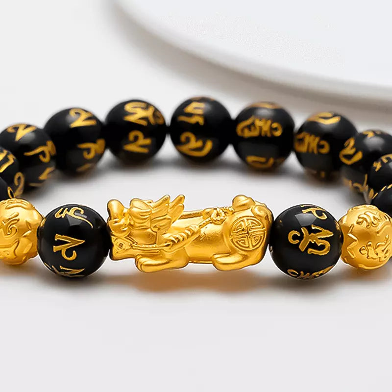 Pulseira da prosperidade Feng Shui com obsidiana negra e charm dourado do Pixiu, simbolizando proteção, sorte e riqueza, ideal para atrair prosperidade - Pelicano Azul