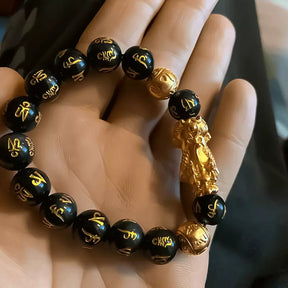 Pulseira da prosperidade Feng Shui com obsidiana negra e charm dourado Pixiu, símbolo de proteção, sorte e riqueza, para atrair energias e prosperidade - Pelicano Azul