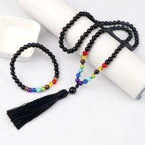 Japamala com 108 contas em Lava Vulcânica e pedras dos 7 Chakras, acompanhado de uma pulseira budista combinando e tassel preto elegante Pelicano Azul.