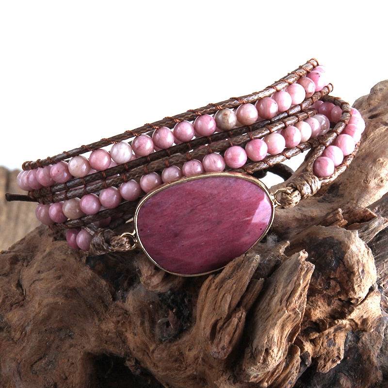 Pulseira Fashion com pedra central de rhodonita em tom rosado, decorada com fileiras de pedras naturais cor-de-rosa, acabamento em couro - Pelicano Azul.