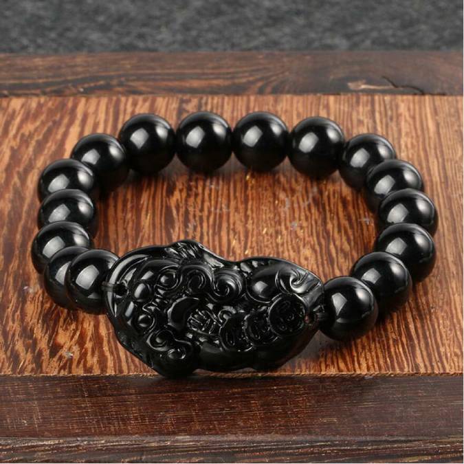 Pulseira de Obsidiana Negra com entalhe Feng Shui, ideal para proteção energética, Pelicano Azul.