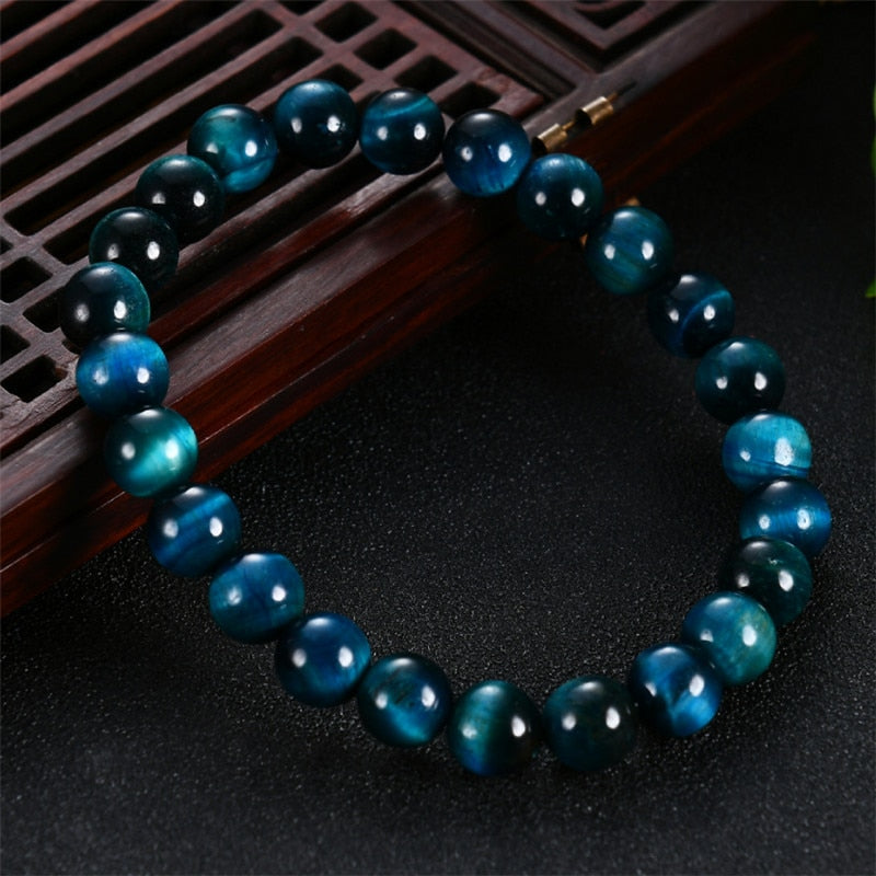 Pulseira de contas redondas de Olho de Tigre Azul com brilho natural, transmitindo equilíbrio e força espiritual, Pelicano Azul.