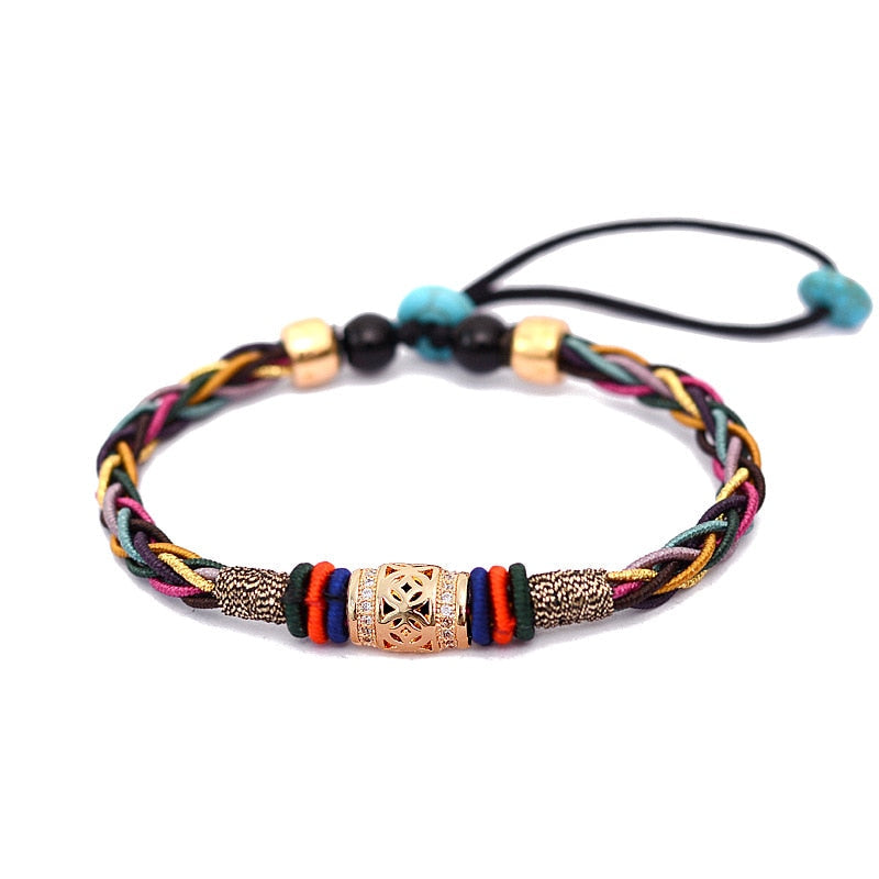 Pulseira Tibetana com 8 fios trançados em várias cores, detalhes em ouro e pedras turquesas, representando saúde e prosperidade, Pelicano Azul.